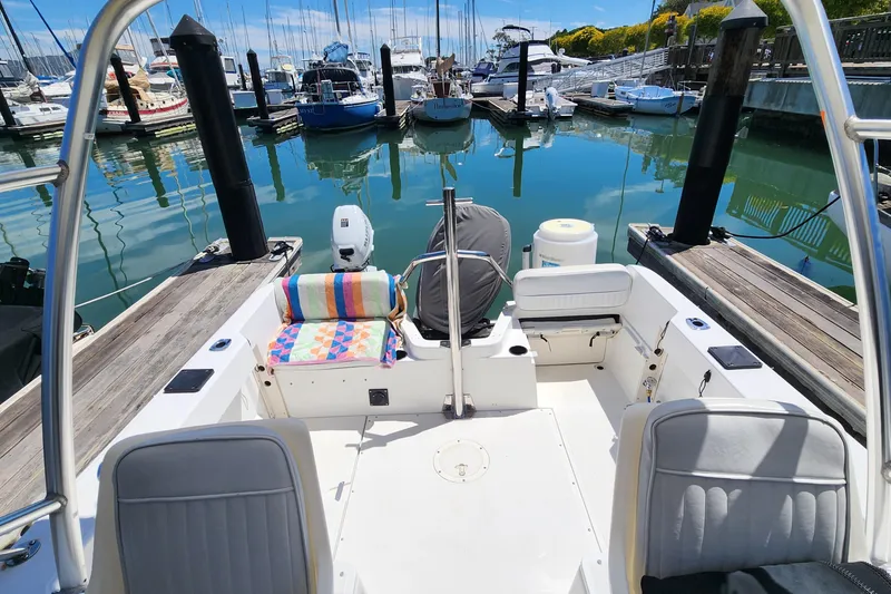 Slide: The Image of Boston Whaler 21 Conquest 2000 docked in a marina with clear blue water. - 11