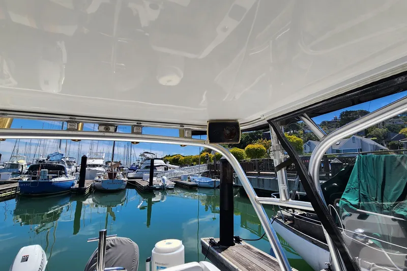 Slide: The Image of Boston Whaler 21 Conquest 2000 at marina, view from under canopy, boats docked nearby. - 12