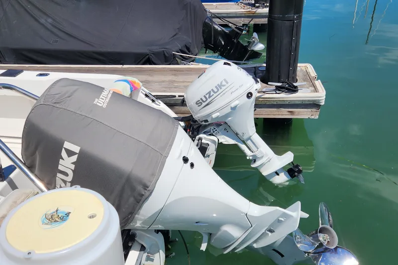 Slide: The Image of Boston Whaler 21 Conquest boat with Suzuki outboard motors docked in clear water. - 7