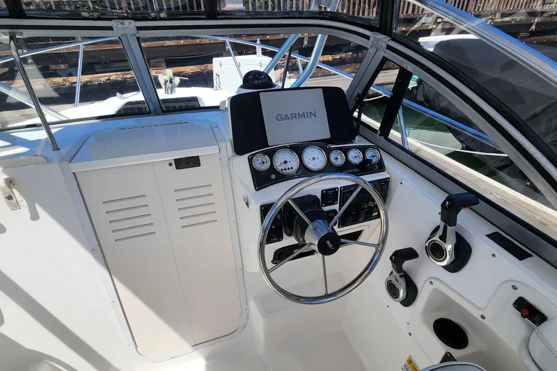 Slide: The Image of Boston Whaler 21 Conquest 2000 boat cockpit with Garmin navigation system and steering wheel. - 8
