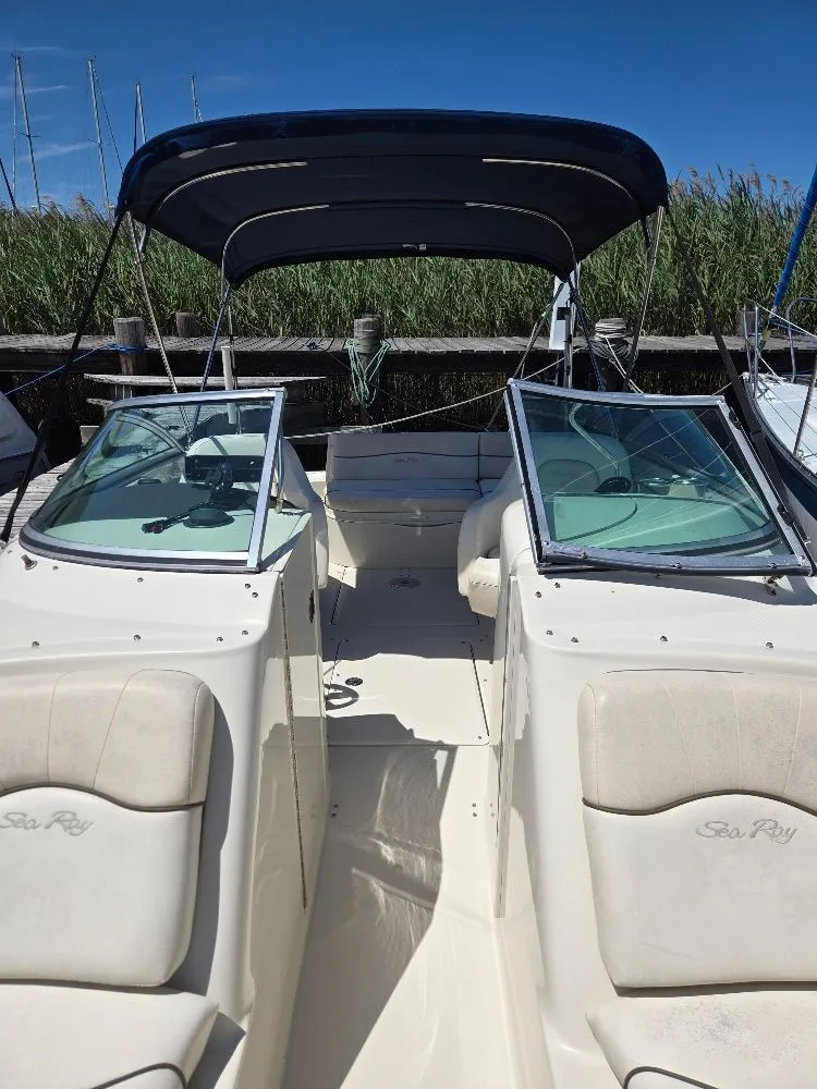 Slide: The Image of 2008 Sea Ray 240 Sundeck boat with canopy, docked under clear blue sky. - 13