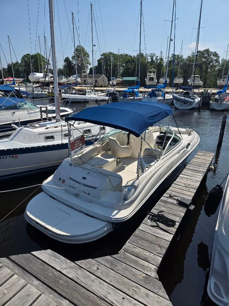 Slide: The Image of 2008 Sea Ray 240 Sundeck boat docked at marina with blue canopy. - 2