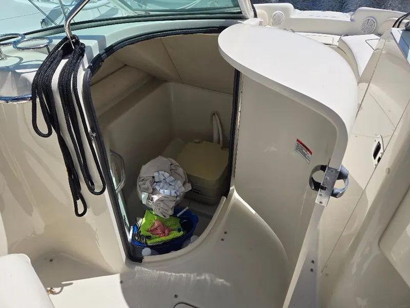 Slide: The Image of 2008 Sea Ray 240 Sundeck boat interior with storage compartment and marine toilet. - 8
