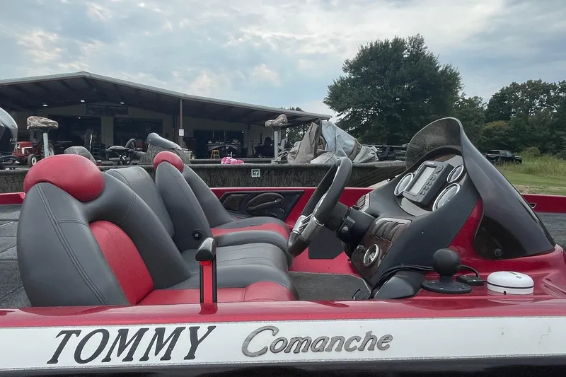 Slide: The Image of 2008 Ranger 520VX boat interior with red and gray seats, parked outdoors. - 3