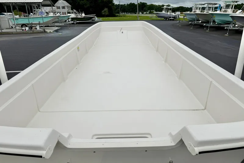 Slide: The Image of 2026 Carolina Skiff E21 DLX Kit Boat, empty deck view at a marina. - 14