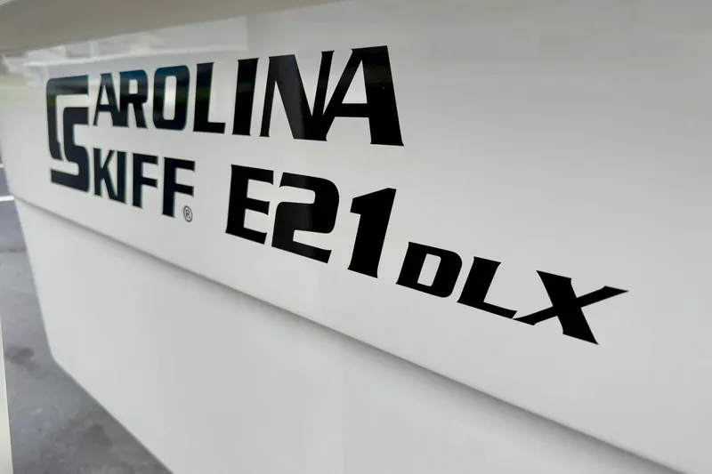 Slide: The Image of 2026 Carolina Skiff E21 DLX Kit Boat logo on white surface. - 15