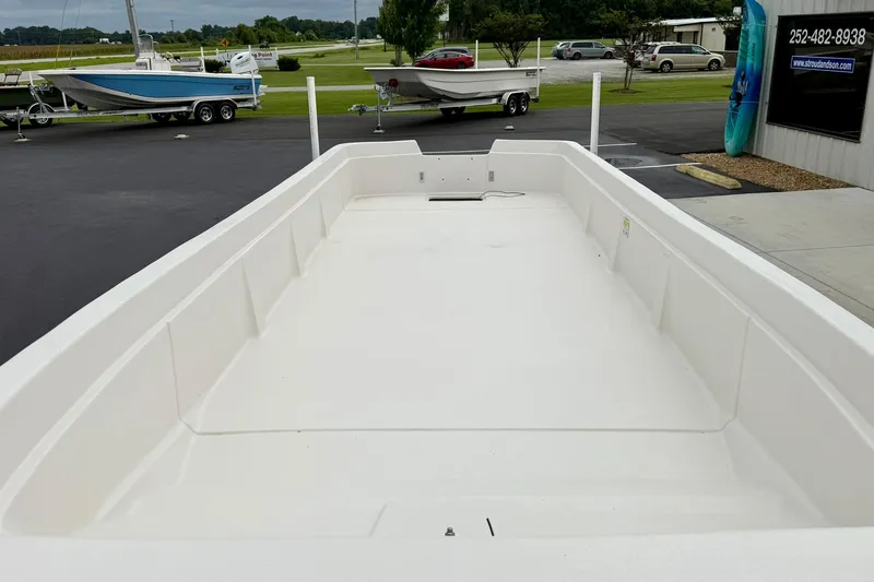 Slide: The Image of 2026 Carolina Skiff E21 DLX Kit Boat, spacious deck, displayed outdoors at a dealership. - 9