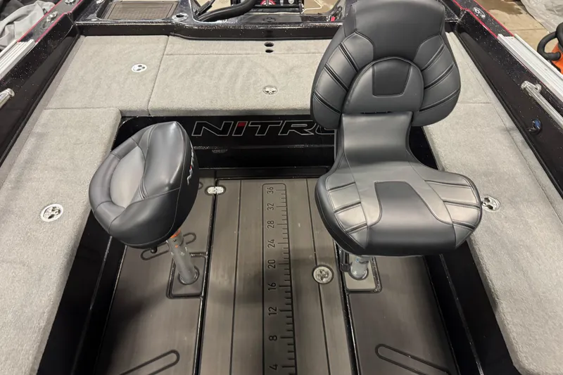 Slide: The Image of 2024 Nitro ZV21 boat interior with two black cushioned seats and gray flooring. - 6