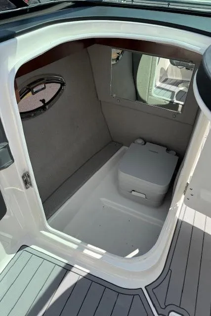 Slide: The Image of 2023 Chaparral 267 SSX boat interior with compact cabin and portable toilet. - 17