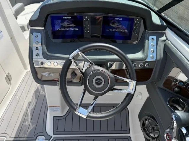 Slide: The Image of 2023 Chaparral 267 SSX boat dashboard with dual displays and modern steering wheel. - 20