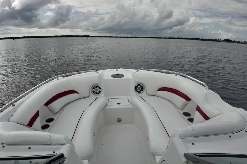 Slide: The Image of 2015 Hurricane SunDeck 2200 OB boat with spacious seating on a calm lake. - 11