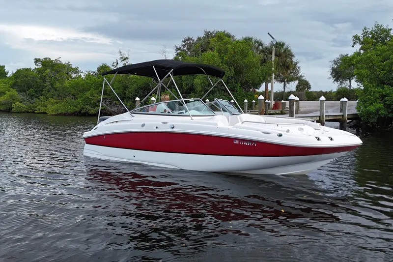 Slide: The Image of 2015 Hurricane SunDeck 2200 OB boat on calm water near lush greenery. - 2