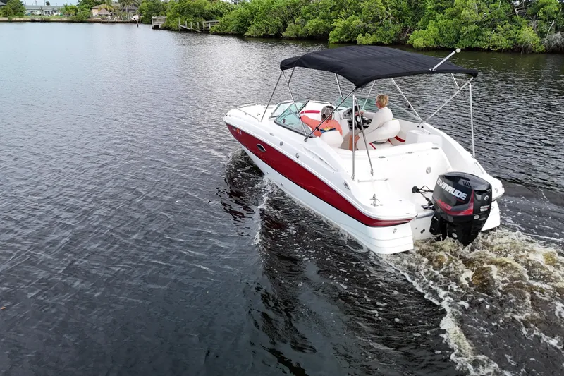 Slide: The Image of 2015 Hurricane SunDeck 2200 OB cruising on a calm river with lush greenery. - 8