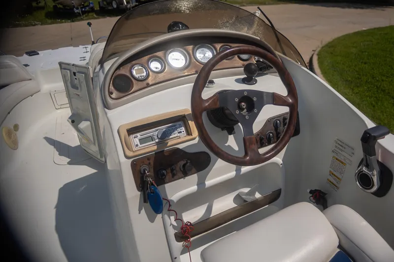 Slide: The Image of 2002 Starcraft AUORA 229 STEP CC DECK boat dashboard with steering wheel and controls. - 11