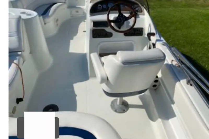 Slide: The Image of 2002 Starcraft AUORA 229 STEP CC DECK boat interior with steering wheel and seating. - 6
