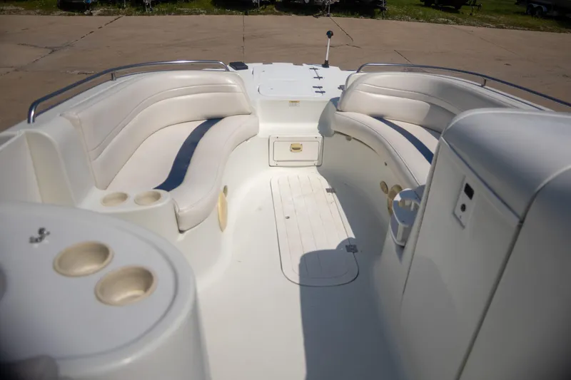 Slide: The Image of 2002 Starcraft AUORA 229 STEP CC DECK boat interior with white seating and cup holders. - 8
