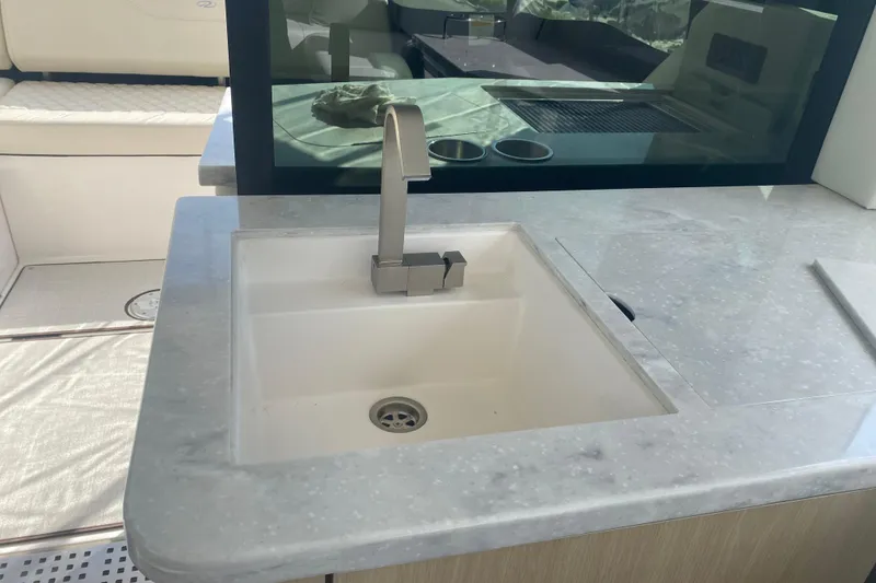 Slide: The Image of Interior of 2023 Regal 38 Grande Coupe yacht with modern kitchen and marina view. - 12