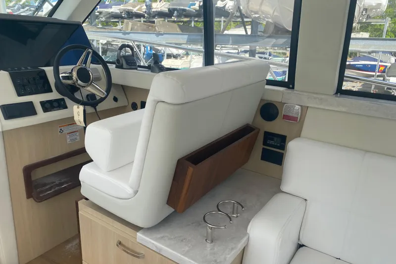 Slide: The Image of Interior of 2023 Regal 38 Grande Coupe with white seating and modern helm. - 17