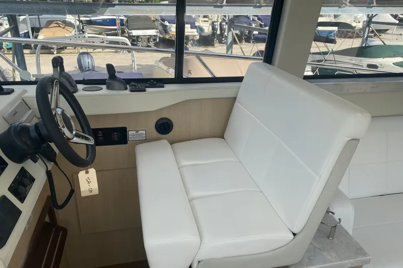 Slide: The Image of Interior of 2023 Regal 38 Grande Coupe with helm and white seating. - 18