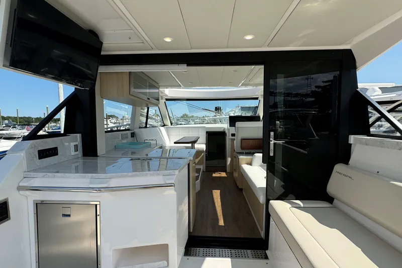 Slide: The Image of Luxurious 2023 Regal 38 Grande Coupe yacht interior with seating and kitchenette. - 7