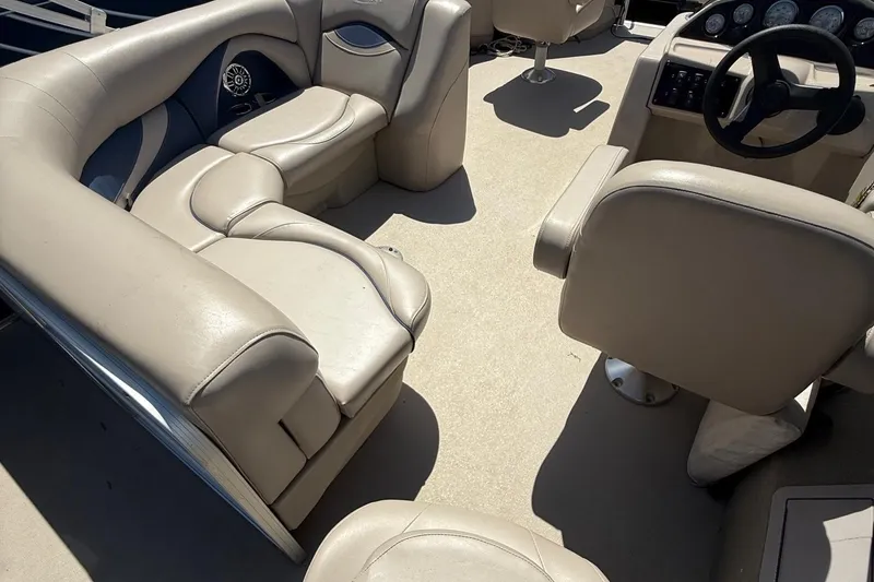 Slide: The Image of 2016 Sylvan Mirage Fish 8520 4-PT boat interior with beige seating and steering console. - 27