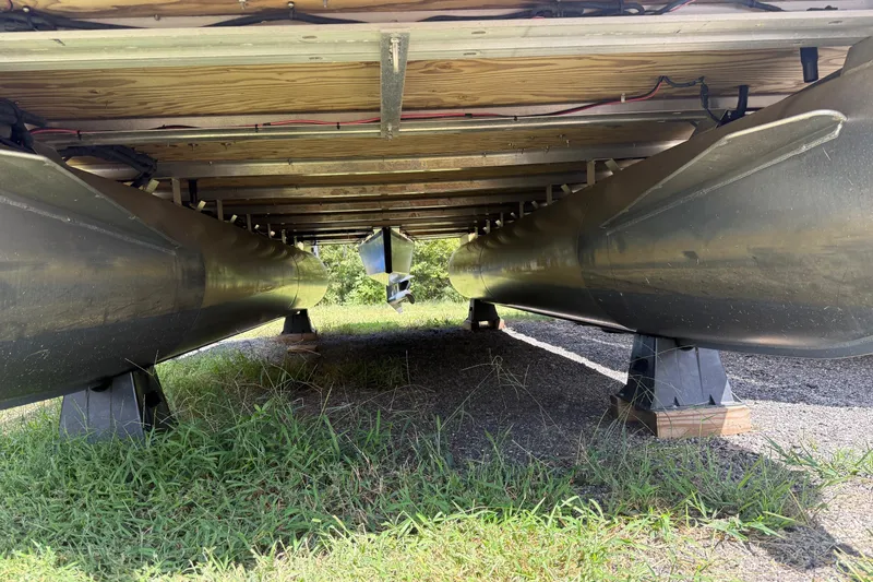 Slide: The Image of Underneath view of a 2016 Sylvan Mirage Fish 8520 4-PT pontoon boat on grass. - 30