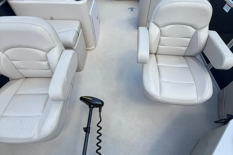 Slide: The Image of 2016 Sylvan Mirage Fish 8520 4-PT boat interior with two white cushioned seats. - 7