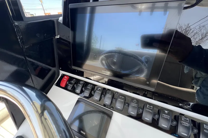 Slide: The Image of 2025 Sea Hunt BX 25 FS boat dashboard with Garmin display and control switches. - 19