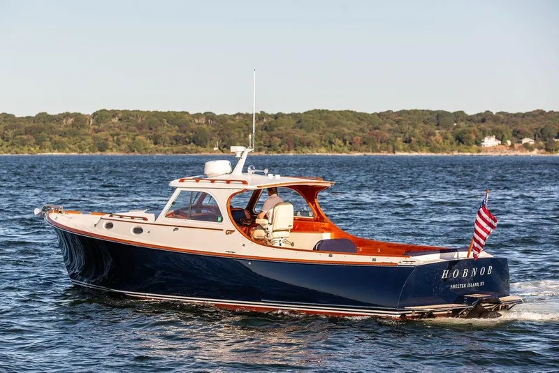 Slide: The Image of 2001 Hinckley Yachts Picnic Boat Classic 36 cruising on open water, American flag displayed. - 1