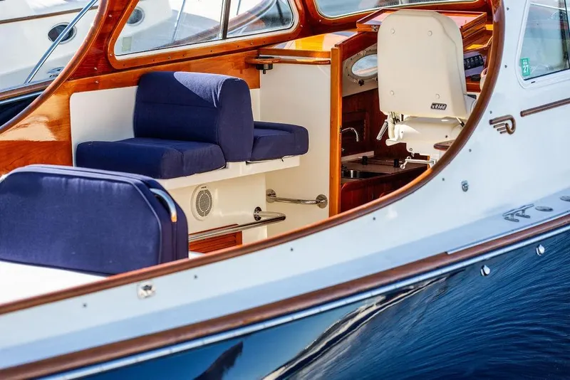 Slide: The Image of 2001 Hinckley Yachts Picnic Boat Classic 36 interior with blue seating and wooden accents. - 10