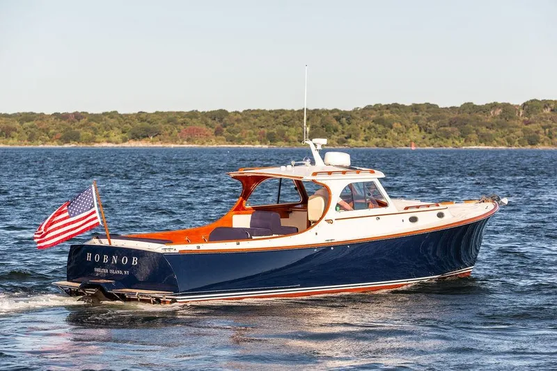 Slide: The Image of 2001 Hinckley Yachts Picnic Boat Classic 36 cruising on water, American flag displayed. - 3