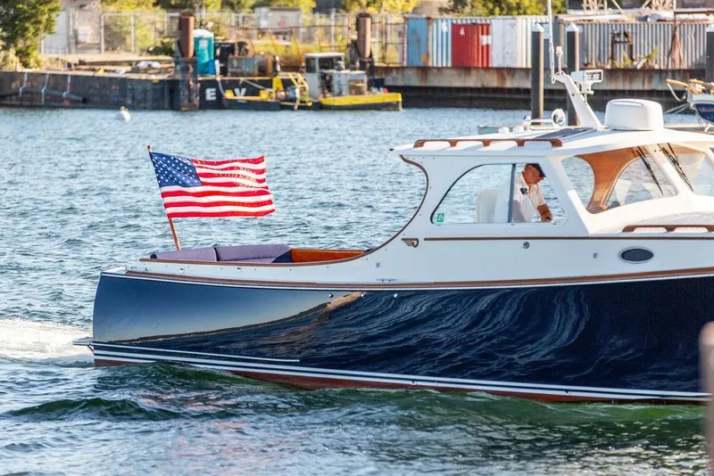 Slide: The Image of 2001 Hinckley Yachts Picnic Boat Classic 36 cruising with American flag on water. - 6