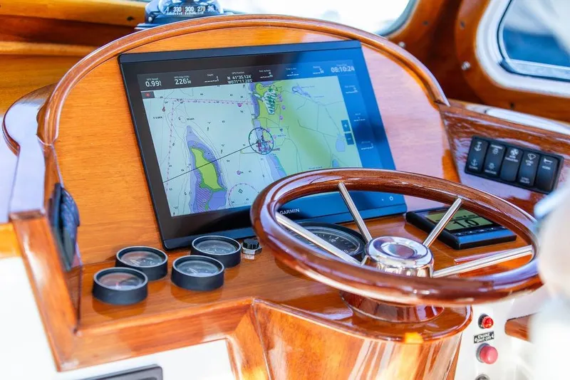 Slide: The Image of Hinckley Yachts Picnic Boat Classic 36 helm with GPS navigation, wooden steering wheel, and gauges. - 7