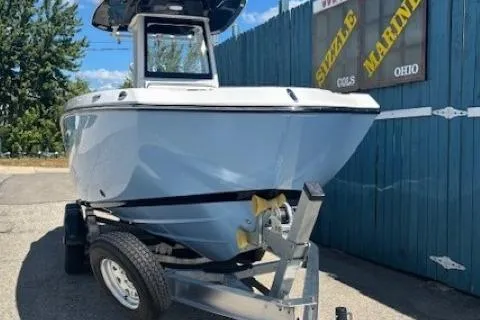 Slide: The Image of 2026 Yamaha Boats 255 FSH Sport H on trailer, parked outdoors near blue fence. - 1