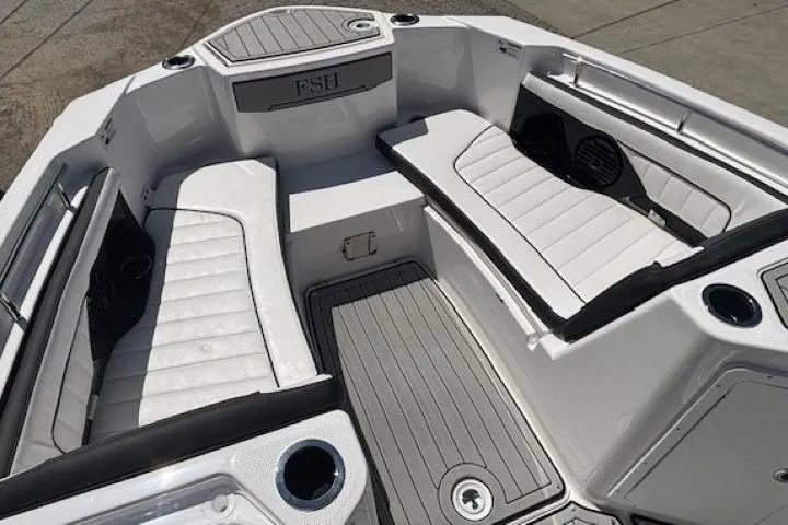 Slide: The Image of 2026 Yamaha Boats 255 FSH Sport H interior with white seating and cup holders. - 10