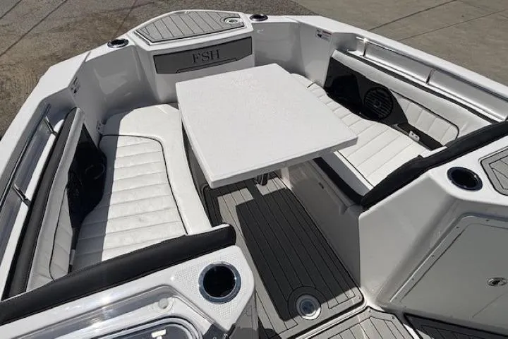 Slide: The Image of 2026 Yamaha Boats 255 FSH Sport H interior with seating and table, featuring sleek design. - 12