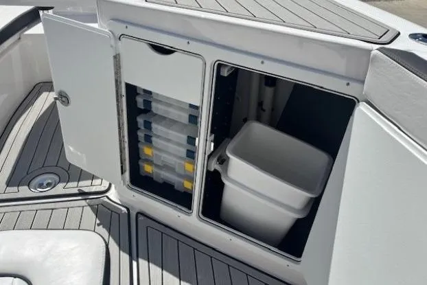 Slide: The Image of 2026 Yamaha Boats 255 FSH Sport H storage compartments with tackle boxes and bin. - 14