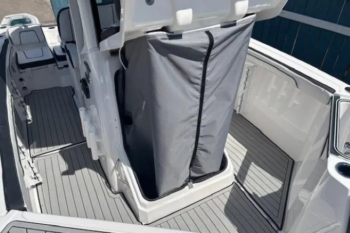 Slide: The Image of 2026 Yamaha Boats 255 FSH Sport H interior with gray flooring and storage area. - 17