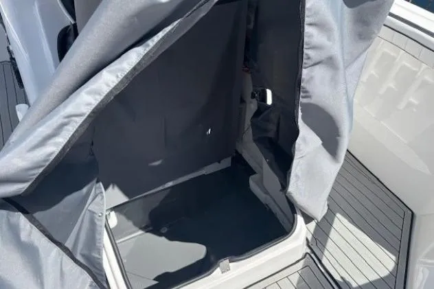 Slide: The Image of 2026 Yamaha Boats 255 FSH Sport H interior storage area with protective cover. - 18