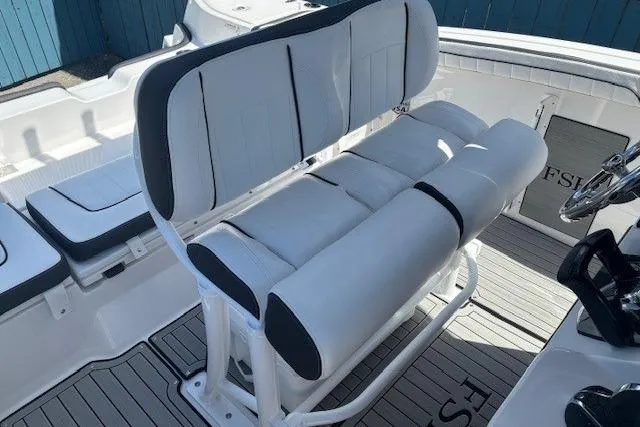 Slide: The Image of 2026 Yamaha Boats 255 FSH Sport H interior seating, featuring sleek white and gray upholstery. - 26