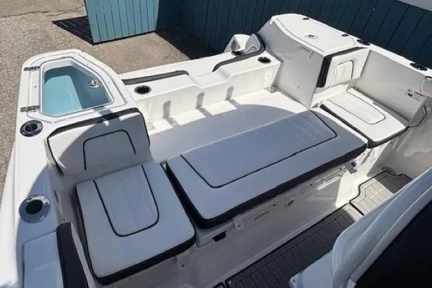 Slide: The Image of 2026 Yamaha Boats 255 FSH Sport H interior with cushioned seating and storage compartments. - 30