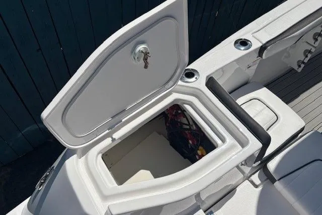 Slide: The Image of 2026 Yamaha Boats 255 FSH Sport H storage compartment with open hatch and visible interior. - 32