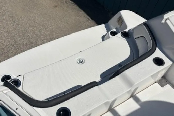 Slide: The Image of 2026 Yamaha Boats 255 FSH Sport H, white deck with cup holders and seating area. - 35