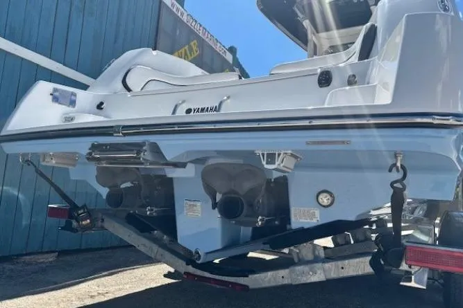 Slide: The Image of 2026 Yamaha Boats 255 FSH Sport H on trailer, rear view, blue and white design. - 4