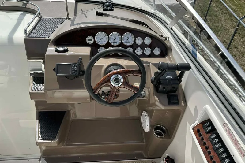 Slide: The Image of 2005 Regal 3350 Sport Cruiser helm with gauges, steering wheel, and controls. - 19