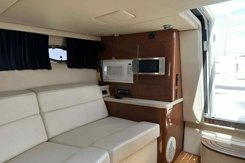 Slide: The Image of Interior of 2005 Regal 3350 Sport Cruiser with sofa, microwave, and wood accents. - 22