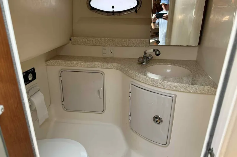Slide: The Image of 2005 Regal 3350 Sport Cruiser bathroom with sink, mirror, and storage cabinets. - 24