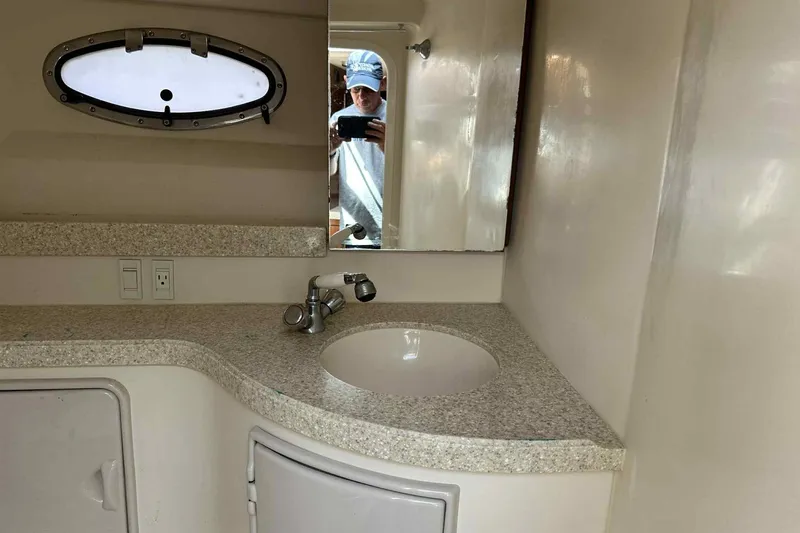 Slide: The Image of 2005 Regal 3350 Sport Cruiser bathroom with sink, mirror, and porthole window. - 32