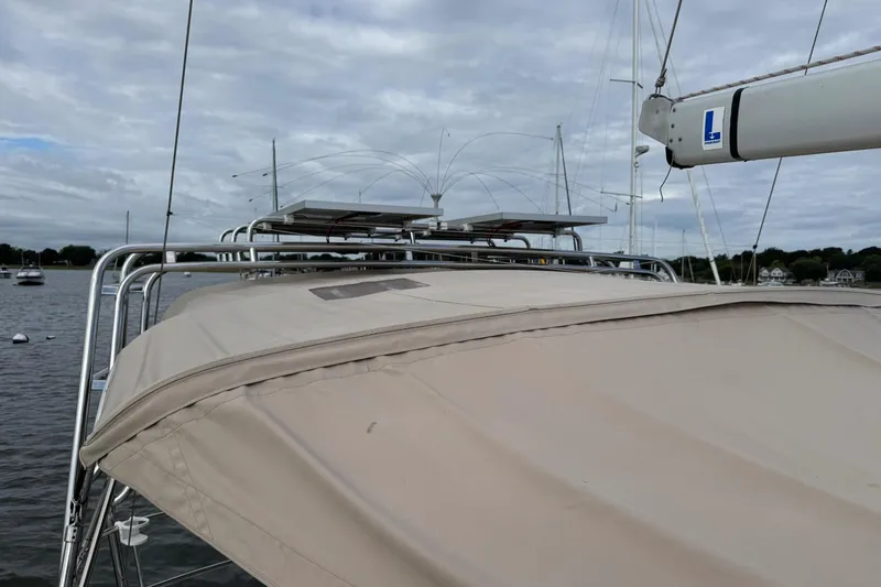 Slide: The Image of Jeanneau 409 sailboat with solar panels on deck, moored in a calm harbor. - 10