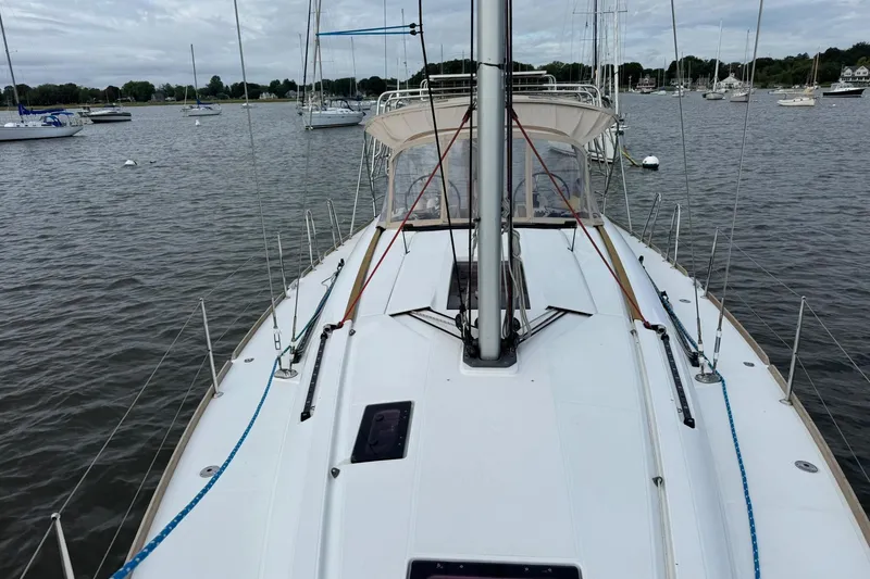 Slide: The Image of Jeanneau 409 sailboat on calm water, surrounded by other boats. - 16